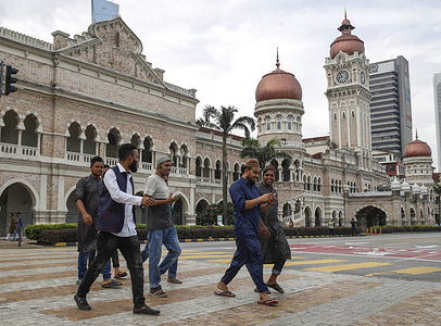 Muslims seen crossing the road after performing the Eid al-Fitr prayers to mark the first day of the month of Syawal at the Sultan Abdul Samad Jamek Mosque in Kuala Lumpur. Muslims around the world celebrate Eid al-Fitr, marking the end of the holy fasting month of Ramadan.