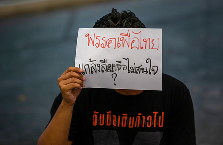 An activist holds a placard in Chiang Mai University during the 14th anniversary of the Red Shirts protest. Activists gather in Chiang Mai Univesity to pay tribute to those who died during the Red Shirts protest that happened in 2010. From March to May 2010, anti-government protests, organized by the United Front for Democracy Against Dictatorship (UDD), resulted in 91 deaths and over 2,000 injuries. The series of protests, led by the UDD, also known as "Red Shirts," aimed to oust the Democrat Party-led government. Despite the UDD's demands for the government to step down and failed negotiations for an election date, the protests escalated into prolonged violent clashes between protesters and the military, with ceasefire attempts proving unsuccessful.