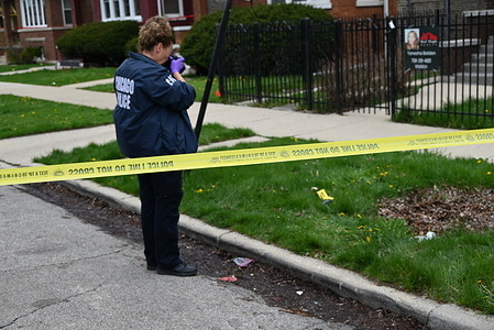 Chicago police officer takes photos of shell casings on the ground, a firearm discovered on the ground and a vehicle struck by gunfire at the crime scene. 20-year-old male shot by another person and taken into custody by police in Chicago, Illinois, United States on April 11, 2024. Thursday afternoon at approximately 2:17 p.m. in the 1500 block of N. Leclaire Avenue, a 20-year-old male victim was discovered to have sustained one gunshot wound to his right leg after being involved in an exchange of gunfire with an unknown individual. The victim was transported to the hospital in good condition and the victim was placed in custody. Detectives are Investigating and at this time, no further information is available.