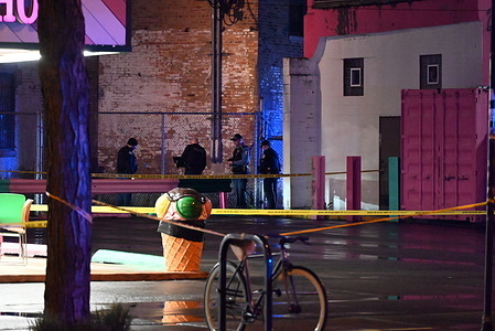 Police officers search for evidence at the crime scene where two people were shot leaving one of them critically wounded. Two people shot as they stood on a sidewalk in Chicago, Illinois, United States on April 12, 2024. At approximately 1:58 a.m., Friday morning two male adults were standing on the sidewalk on the 1800 block of S. Blue Island Avenue when a white vehicle approached from the alley and a suspect fired gunshots in their direction and then fled the scene. A 31-year-old male sustained a gunshot wound to the back and was transported to the hospital in critical condition, a 25-year-old male sustained a gunshot wound to the left leg and was transported to the hospital in good condition. No suspects are in custody and detectives are investigating the shooting.
