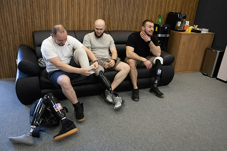 Ukrainian servicemen who lost a limb in battles with the Russian army communicate in the recreation area of a volunteer prosthetics center in Kyiv.