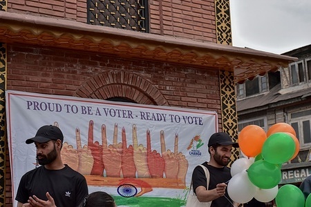 Kashmiri artist holds balloons in the tri-colours of the Indian national flag during an event organised by the District Election Office to raise awareness about voting in India's upcoming general elections in Srinagar.