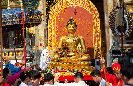 Thai people offer flowers during The Phra Buddha Sihing Buddha statue procession to mark Songkran celebrations at Wat Phra Singh Woramahaviharn temple. Songkran is also known as the water festival which is celebrated on the Thai traditional New Year's day annually on 13 April by spraying water and throwing powder at each others faces as a symbolic sign of cleansing and washing away the sins from the past year.