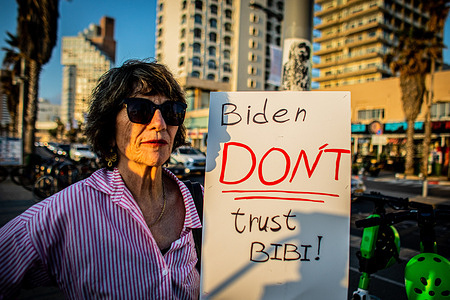 A protester holds a placard calling on U.S President Joe Biden not to trust Israeli Prime Minister Benjamin Netanyahu during a demonstration. Israel has vowed to "exact a price" from Iran after an unprecedented large-scale drone and missile attack over the weekend that escalated regional tensions stoked by the war in Gaza.