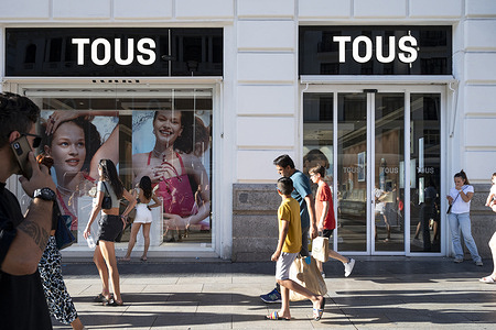 Pedestrians and shoppers walk past the Spanish jewelry, accessories, and fashion retailer Tous store in Spain.