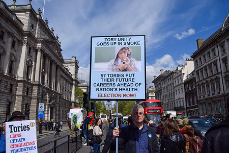 A protester in Parliament Square holds a placard referencing the 57 Tories who voted against the smoking ban. Anti-Tory activists staged their weekly protest as Rishi Sunak faced Prime Minister's Questions.
