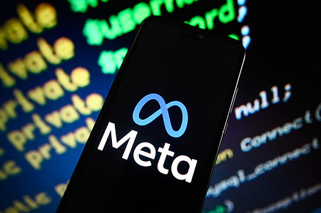 In this photo illustration, a META logo is displayed on a smartphone with coding lines in the background.