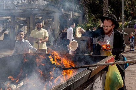 A Jewish man seen throwing leaven into the fire during the Biur Chametz. During the Biur Chametz, religious Jews fulfill their obligation to inspect their homes for any leaven and eliminate it before the night of Passover. In ultra-Orthodox cities in Israel, fires are set up in major locations in the city for this purpose, where people bring their bread leftovers to burn the leaven. During the seven days of Passover, they are prohibited from eating or possessing any leaven, symbolizing the dough the Israelites did not have time to allow to rise before the Exodus from Egypt. Biur Chametz, also known as 'the burning of the leavened goods,' is a Jewish ceremonial ritual involving the burning of leavened foods (chamets) to mark the start of Passover.