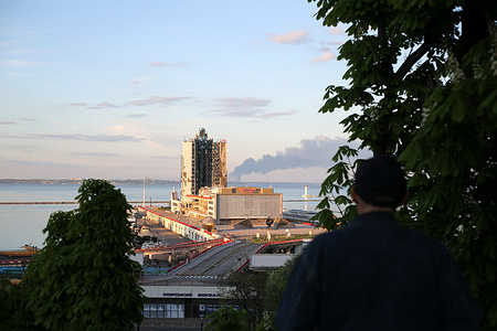 A man standing on Primorsky Boulevard looks at the smoke rising from a Russian missile attack on Odessa Marine Station. One man sustained injuries following a shelling attack by Russian forces in the Odessa region on the afternoon of April 19, 2024. According to local military administrator Oleh Kiper, the strike had damaged port infrastructure in the area.