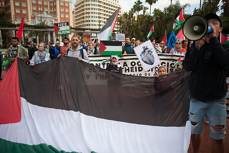 Protesters hold a huge Palestinian flag as they take part in a nationwide demonstration in solidarity with Palestinian people, following the conflicts between Israel and Hamas. Under the slogan "Stop genocide in Palestine", hundreds of people demand an end to the arms trade and trade relations with Israel.