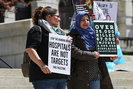 Protesters hold placards expressing their opinion during a healthcare workers rally for Gaza outside of the Pennsylvania State Capitol. The protest was organized in response to Israel's two-week siege and destruction of Gaza's Al-Shifa Hospital in which healthcare workers and patients were killed.