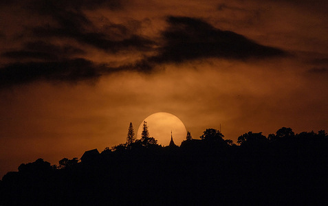 The Sun sets with clouds obscured behind the Phra That Doi Suthep pagoda at Doi Suthep mountain, in Chiang Mai.
