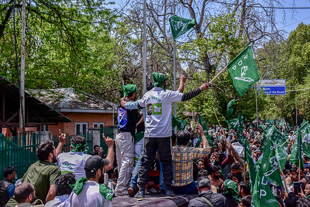 Supporters of Peoples Democratic Party (PDP) hold party flags as they take part in an election rally in Srinagar.