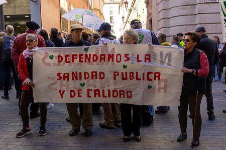 A group of protesters hold a banner during a rally. Activists from neighborhood movements of Madrid presented more than 7,000 signatures with complaints to the Government of the Community of Madrid, demanding that public health not be abandoned from the autonomous administration and that resources not be diverted towards private health.