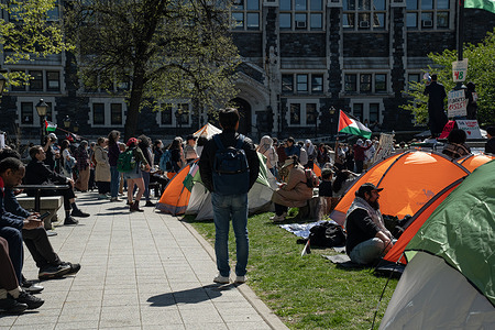 A fellow City College of New York (CCNY) student watches as demonstrators set up a "Palestine Solidarity" tent encampment in the quad outside of the High School for Math, Science and Engineering on April 25, 2024 in New York City.