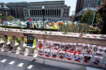 A wall with Hamas hostage flyers posted in front of a pro-Palestine encampment at Columbia University in New York City.