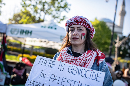 A protester holds a placard that says "There is a genocide in Palestine, don't sleep say no to genocide" during a demonstration. The sit-in protest initiated by the Human Rights and Freedoms (IHH) Humanitarian Relief Foundation at Sultanahmet Square in support of Palestine under Israeli attacks continues on its third day.