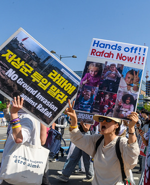 Pro-Palestinian supporters hold placards during a protest. Pro-Palestinian supporters march downtown Seoul calling for Stop Genocide Now! and No Ground Invasion of Rafah!.