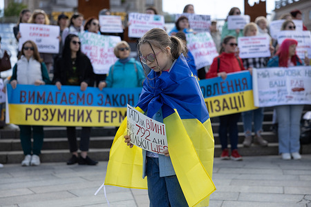 A girl holds placard saying 'Dad has been at war for 792 days already. How much more?' as she take part during a rally calling for demobilization terms to be set up, at the Independence Square in Kyiv. People gathered to demand the terms of length of service in the army, being on the frontline, and fair rotation. The demobilization terms are not prescribed in a new mobilization law which was adopted by the Ukrainian Parliament and signed by President Zelensky recently.