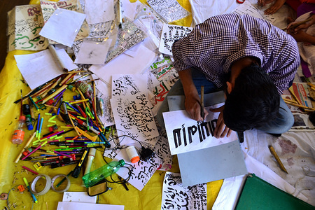 A Calligrapher at work at an exhibition organized by the Tourism department in Srinagar, Indian administered Kashmir. Around 50 students from different schools of Srinagar, artists from Cultural Academy and other artists had put on display their calligraphic works in Arabic, Persian and Kashmiri language.