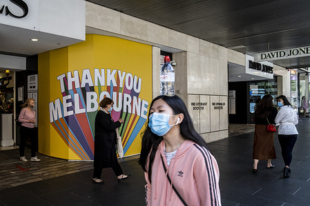 A woman wearing a face mask walks by David Jones windows "Thank You Melbourne" at Bourke Street mall during the reopening.
Melbourne city is full of people shopping and enjoying the first day of eased restrictions, where stores, pubs, restaurants are all reopened.