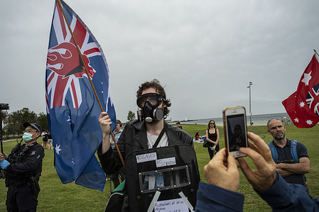 A protester is seen wearing a respirator and protective goggles while holding a flag and a shield with slogans against the lockdown during the he Freedom Day protest.
Despite the city’s tough lockdown being over and coronavirus restrictions largely reduced, anti-lockdown and freedom protesters gathered on Fawkner Park at 2pm on Saturday as they waved flags, chanted and sang songs with massive police presence at the park. The protest again falls on the eve of another easing of restrictions across Victoria, with Premier Daniel Andrews expected to announce more rule changes on Sunday to “lock in” a COVID-safe summer.