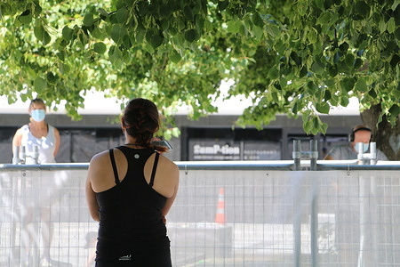 A woman stands on a planter while talking to two people at a quarantine facility.
With the far more transmissible variants of the virus, New Zealanders are questioningwhether we should be allowing kiwis to return at all.