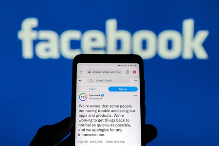 In this photo illustration a tweet on Twitter with a Facebook status seen displayed on a smartphone screen with a facebook logo background.
Social media applications Facebook, Instagram and WhatsApp are experiencing a global outage.