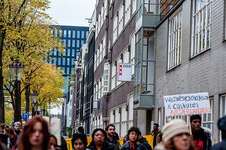 Protesters are seen listening to some speeches, in front of the GGD (Public Heath Care) building during the demonstration.
'We Are Here' is a group of undocumented people who have been in Amsterdam for between 5 and 35 years. All of them live in one of the shelters of the Amsterdam city council, under the pilot project LVV (Landelijke Vreemdelingen Voorziening) (Plan and process evaluation National Foreigners Facilities). Because this is only temporary, their time is running out now and the group have organized a demonstration to demand real solutions. The demonstration passed in front of the several LVV locations and ended at the city center.