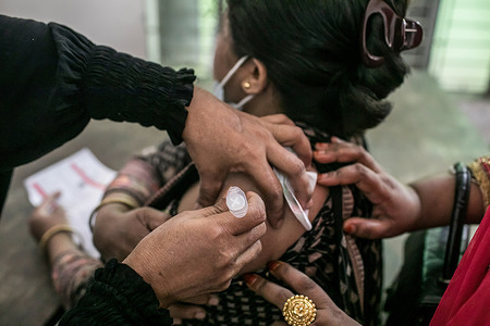 A woman receives a second dose of Sinopharm COVID-19 vaccine during a mass vaccinationat avaccination center in Dhaka.According to the Bangladesh Directorate General of Health Services (DGHS), the nationwide mass vaccination program aims at injecting 7.5 million people to mark the 75th birthday of Bangladeshi Prime Minister Sheikh Hasina.