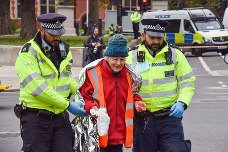 Police officers arrest a protester during the demonstration in Parliament Square. 
Insulate Britain protesters glued themselves to the road and blocked Parliament Square. The protesters are demanding that the government insulates all social housing by 2025, and takes responsibility for ensuring that all homes in the UK are more energy efficient by 2030, as part of wider climate change and decarbonization targets.