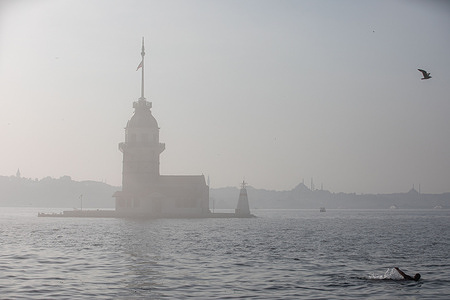 Maiden's Tower seen on Uskudar Salacak beach amidst heavy fog in Istanbul.