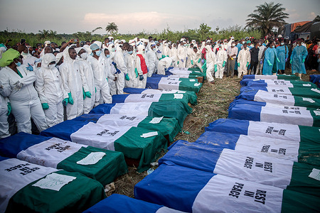 Coffins containing victims of the fuel tanker explosion seen lined up during a mass burial in Freetown.
At least 107 people were killed after a turning fuel tanker was hit at speed by a truck and the leaking fuel caught fire. The victims included women traders, motorbike drivers who rushed to collect the fuel, and passengers in minibuses.