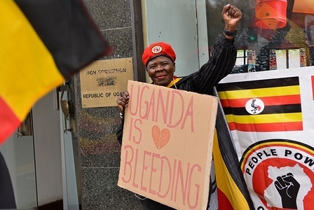 A protester holds a placard that says Uganda is Bleeding opposite Uganda House, at Trafalgar Square during the demonstration.
Ugandans in the UK held a protest at the Uganda High Commission in London and called on the UK government to speak up against detention of political activists and human rights abuses.