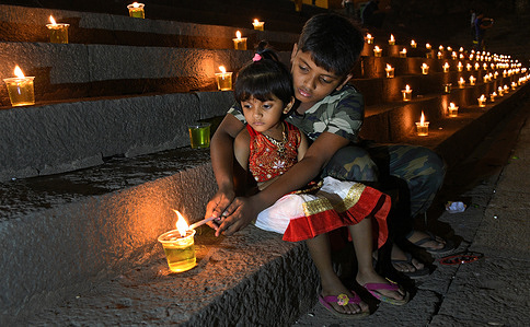 Children seen lighting a diya (earthen lamp) at Banganga water tank during the celebration. 
Dev Diwali is celebrated by Hindus by lighting up diyas (earthen lamps). It also commemorate Lord Shiva's win over the asuras (demons).