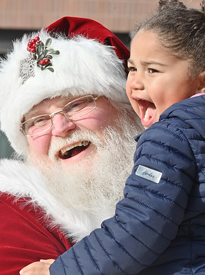 A man portraying Santa Claus laughs with a young girl during a holiday market.
A man portrays Santa Claus at a holiday marketplace and interacts with children as the kick off of the Christmas season on Small Business Saturday.