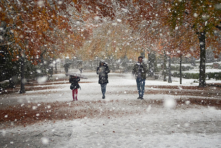 A family walks through the park, during the Arwen snow storm in Pamplona.