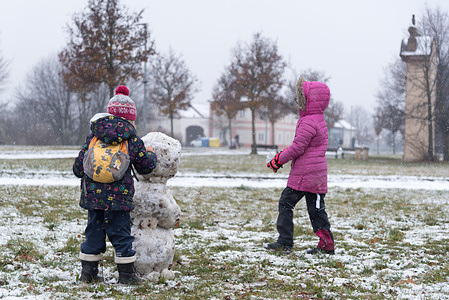 Children build snowman in Ladronka park in Prague. 
Snowing is being observed in Czech republic during the weekend.