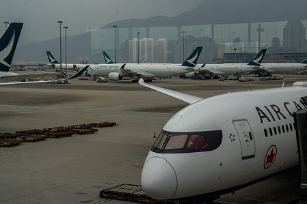 Air Canada plan seen in front of Cathay Pacific planes. 
The Hong Kong International Airport during COVID-19 pandemic.
