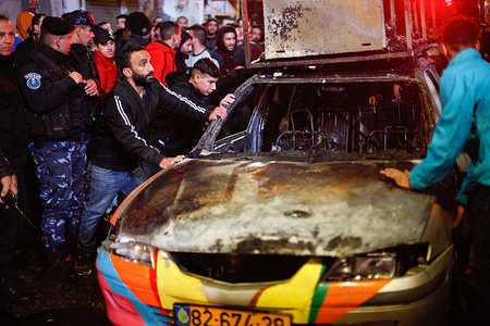 Palestinian police move the Israeli settler's burnt car that was set on fire in Ramallah.
A group of young men set the Israeli settler's car on fire after it entered the territory of Palestine. No injuries or deaths were reported.