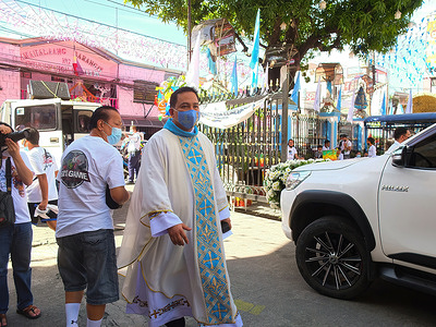 A church parish priest wearing a facemask observes the movement of the convoy with the replica of the Virgin Mary.
Town folks in Malabon City, celebrated the Feast of the Immaculate Conception, amidst the pending threat of the Covid-19 Omicron Variant in the Philippines.