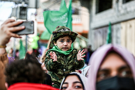 A Palestinian child is seen among the crowd of Hamas supporters during a rally marking the 34th founding anniversary of the resistance movement at Jabalia refugee camp.
Thousands of Hamas members and supporters participated in a massive rally organized by the Islamic Resistance Movement "Hamas" during its 34th founding anniversary at the Jabalia camp for Palestinian refugees located in the northern Gaza Strip.