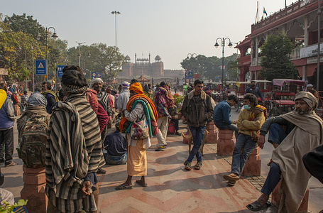 A group of homeless people seen sitting at the roadside, by the busy walkway in front of Temple, waiting for free food at Chandni chowk road.
Homeless people waiting for food in the morning, some benevolent charitable organizations or individuals donate food every day among the homeless people in Delhi.