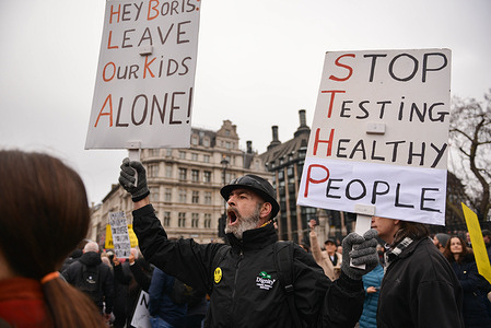 Protesters hold placards expressing their opinion while shouting slogans, during the demonstration.Anti vaccine and anti vaccine pass protesters joined by opponents of Covid 19 restrictions, gathered at Parliament Square and marched through central London.