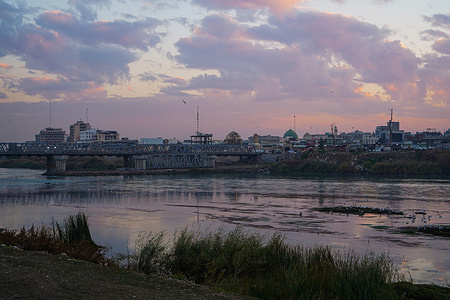 Sunset behind the old bridge over Tigris River in the northern Iraqi city of Mosul.