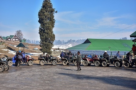 ATV riders wait for tourists during a cold winter day at a famous ski resort in Gulmarg, about 55kms from Srinagar.