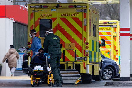 Paramedics wheel a stretcher towards the Accident and Emergency entrance at St Thomas’ Hospital in London.
 Covid-19 hospitalisations are rising in the UK amid the latest wave of Covid-19 infections being fueled by the Omicron variant. Although the numbers remain far below peak, the infection rate threatens to overwhelm the NHS, and may cause staff shortages as workers are forced to quarantine.