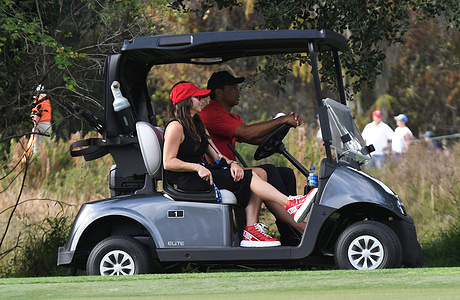 Tiger Woods drives a golf cart with passengers, daughter Sam Woods (obscured) and girlfriend, Erica Herman on the ninth hole during the final round of the PNC Championship at the Ritz-Carlton Golf Club Grande Lakes in Orlando. Tiger and his son, Charlie Woods, set a tournament record with 11 consecutive birdies on Sunday, shooting a 15-under-par 57 and finishing second in the 36-hole tournament.