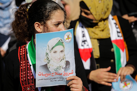 A Palestinian protester holds a poster with a picture of Shorouk Dwaiyat, during a protest organized by the Islamic Jihad in solidarity with female Palestinian prisoners held in Israeli jails, outside the Red Cross office in Gaza city.