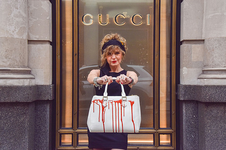 An activist holds a handbag splashed with fake blood during the protest.
PETA (People for the Ethical Treatment of Animals) activists gathered outside the Gucci store on Bond Street and staged a 'catwalk' with handbags splashed with fake blood in protest against the use of lizard skins in Gucci's products. PETA's investigation has shown that the lizard skin suppliers fall well below animal welfare standards and cause huge suffering for the animals.